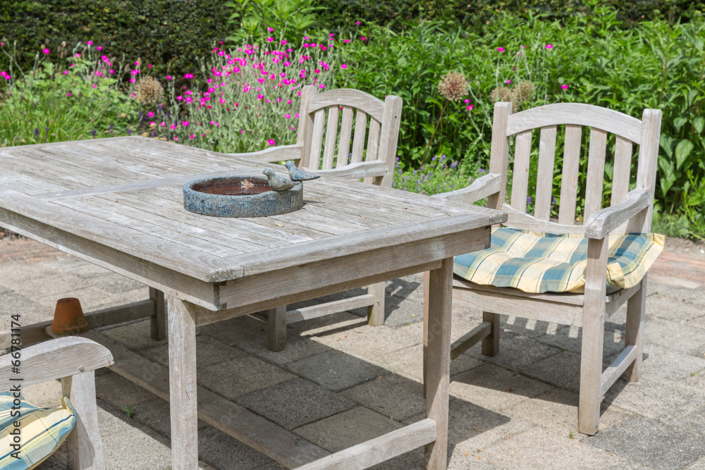 Wooden table and chairs in an ornamental garden Wooden table and chairs in an ornamental garden