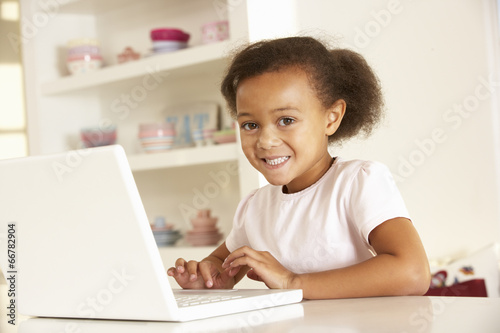 Young girl working on laptop at home