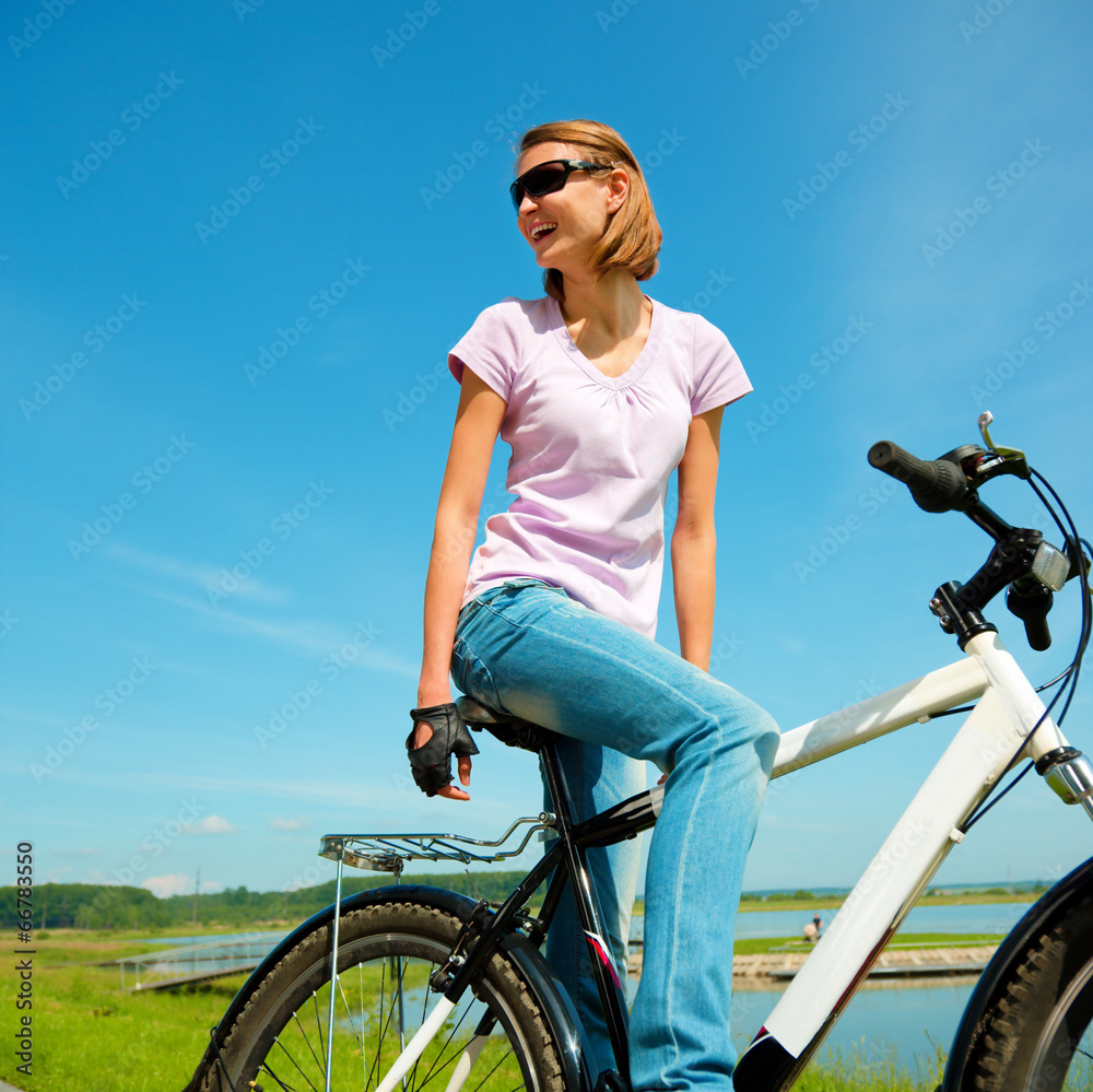 Young woman is sitting on her bicycle Young woman is sitting on her bicycle