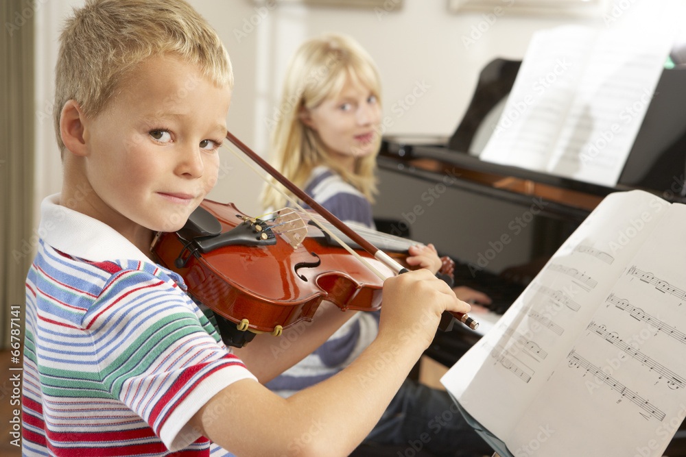 Boy and girl playing violin and piano at home Boy and girl playing violin and piano at home
