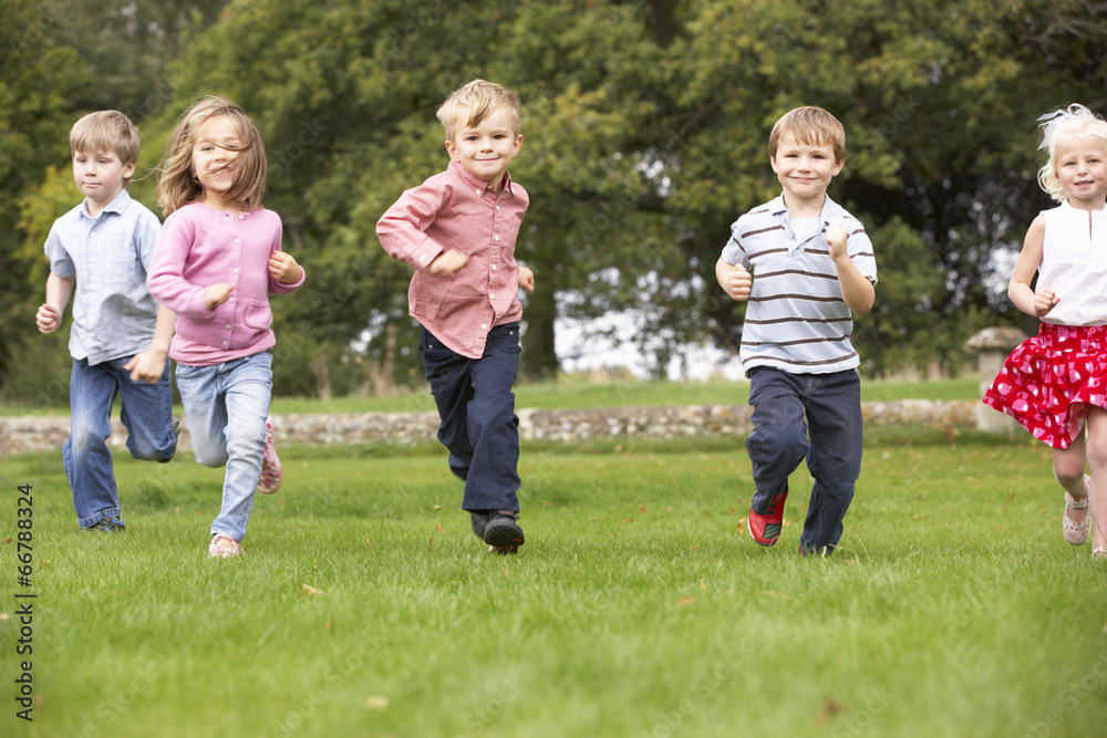 Small group young children running in park
