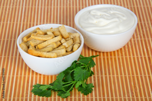 Sour cream, a bowl with toasts and parsley