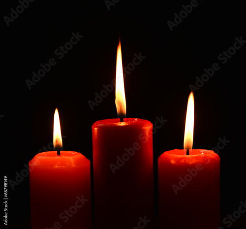 Closeup of burning candles on black background photo