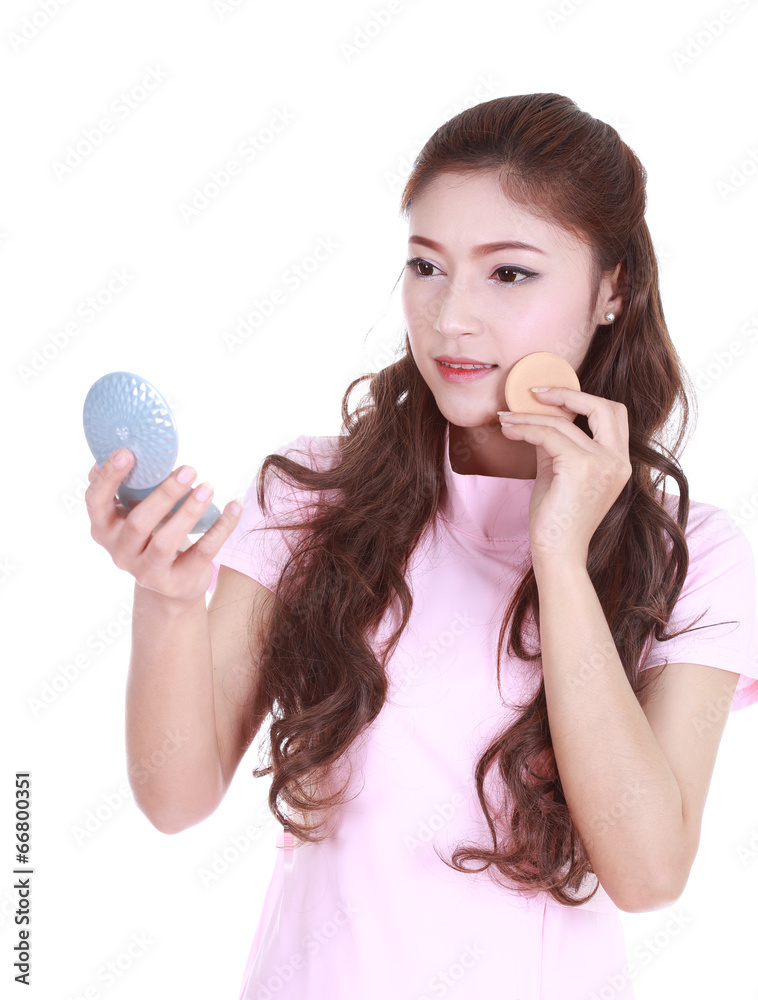 woman looking into the mirror and applying cosmetics woman looking into the mirror and applying cosmetics