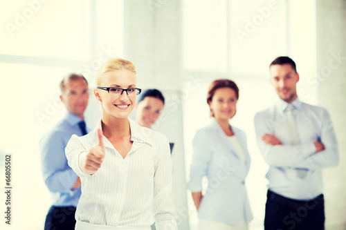 businesswoman in office showign thumbs up