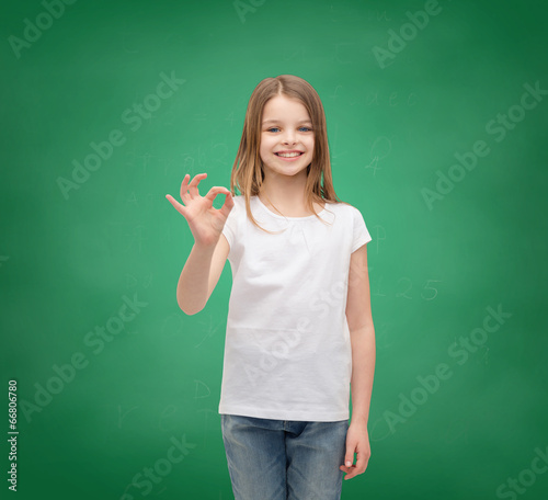 little girl in white t-shirt showing ok gesture © Syda Productions