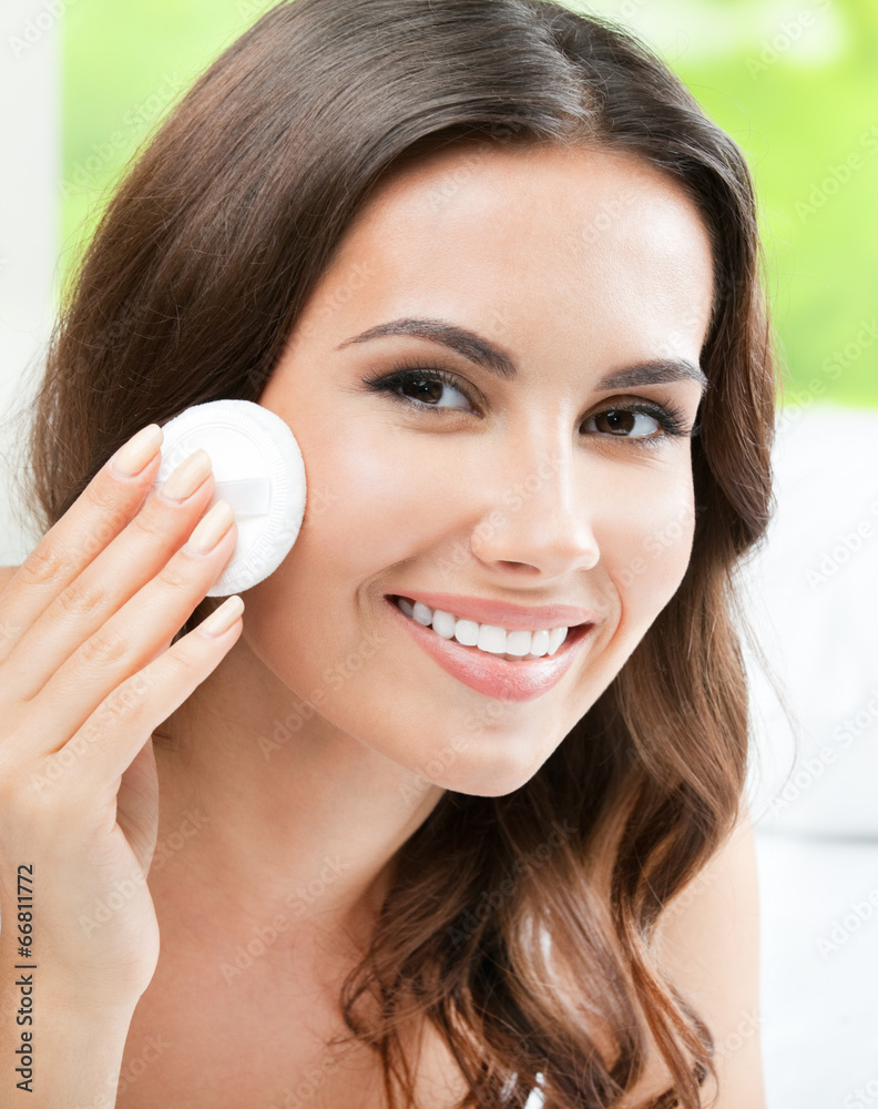 Woman cleaning skin by cotton pad, at home Woman cleaning skin by cotton pad, at home