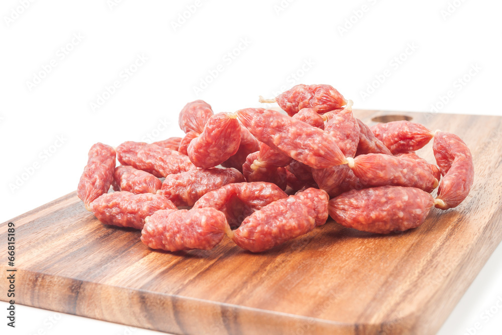 A heap of mini Salamis on wooden board A heap of mini Salamis on wooden board