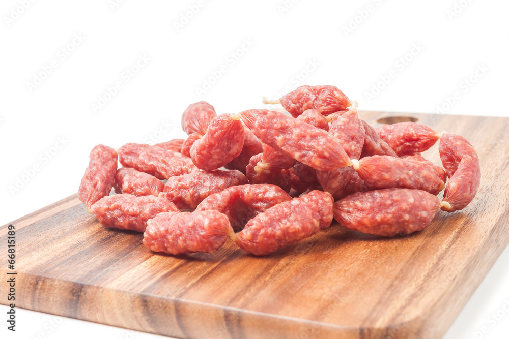 A heap of mini Salamis on wooden board