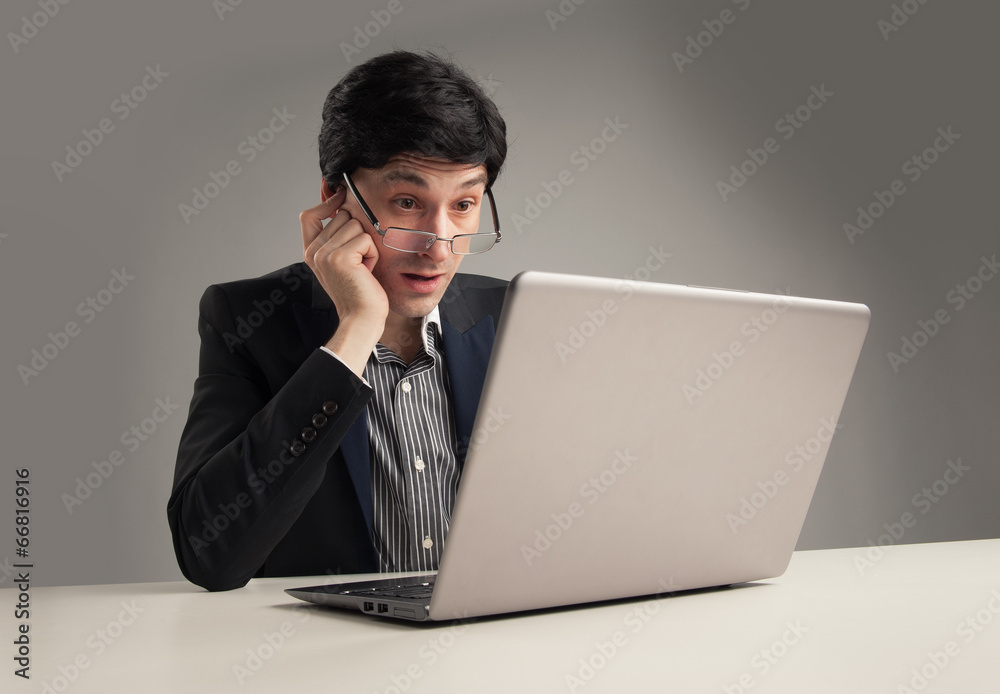 surprised businessman in office working on his laptop surprised businessman in office working on his laptop