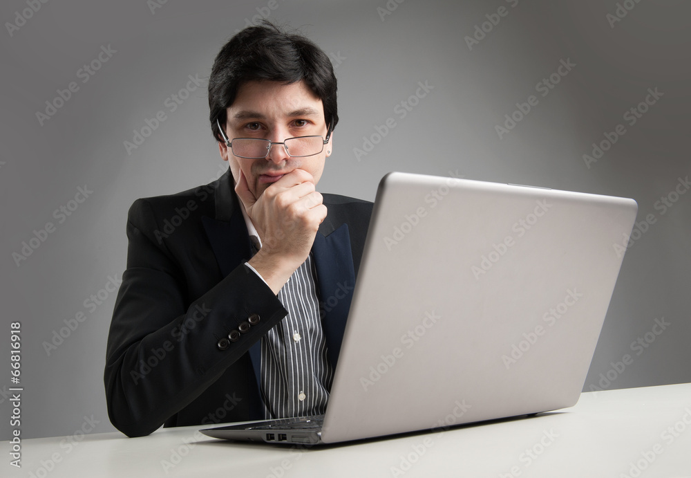 serious businessman in office working on his laptop serious businessman in office working on his laptop