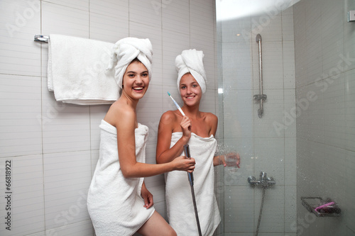 Две девушки в банных полотенцах в душевой photo