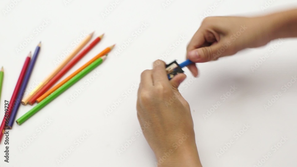 Woman hand using sharpener with color pencil on white desk Woman hand using sharpener with color pencil on white desk