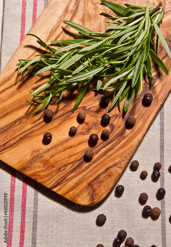 rosemary, pepper and allspice on rustic wooden table 