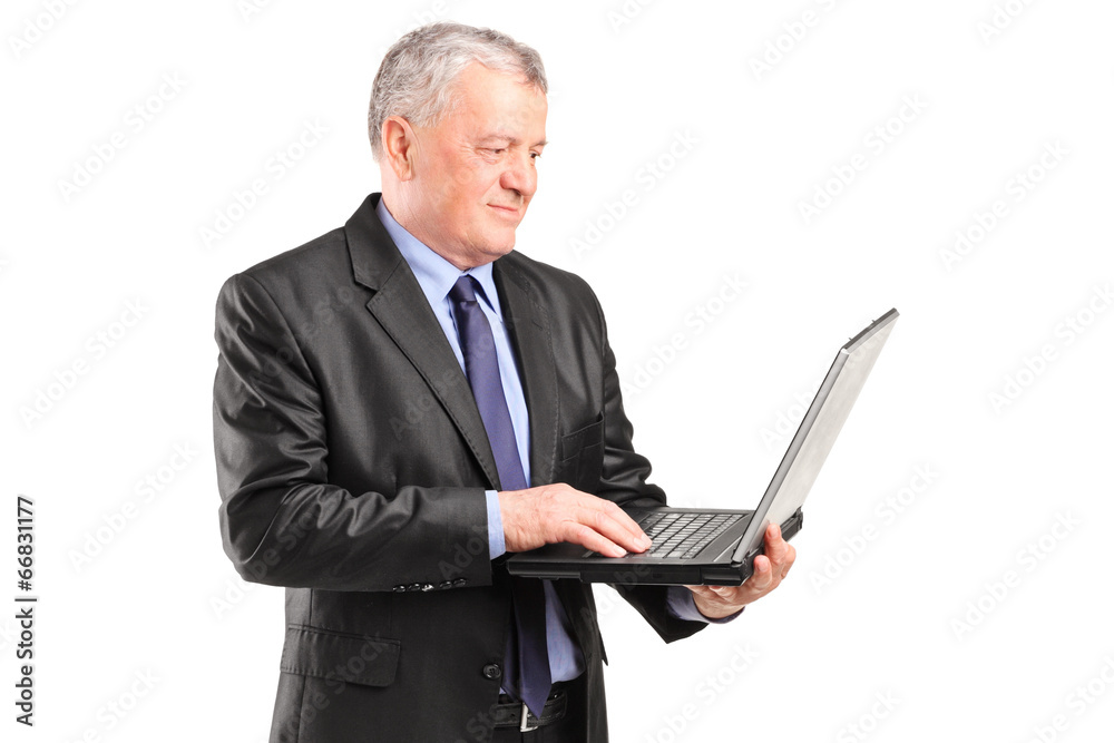 Mature businessman holding a laptop Mature businessman holding a laptop
