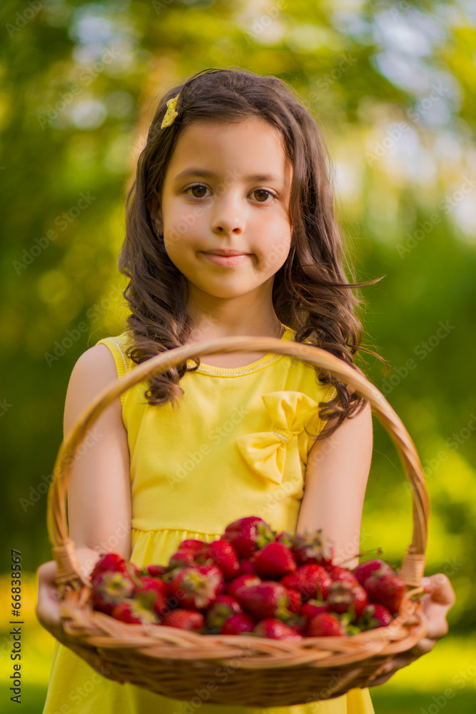 Happy little girl holding basket with fresh strawberries .Select Happy little girl holding basket with fresh strawberries .Select
