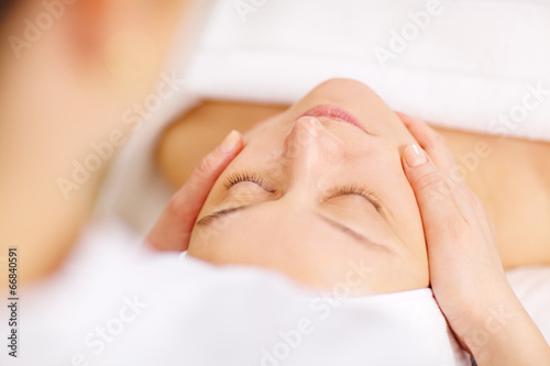 Woman under professional facial massage in beauty spa photo