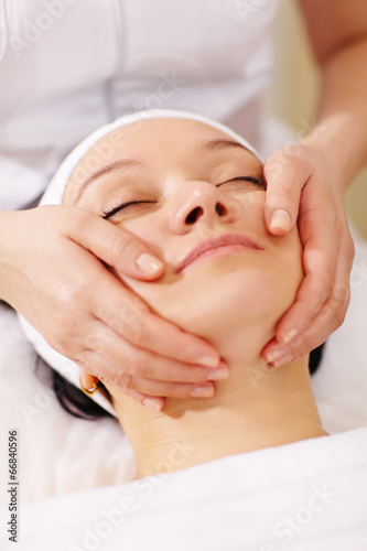Woman in the beauty spa getting a facial massage