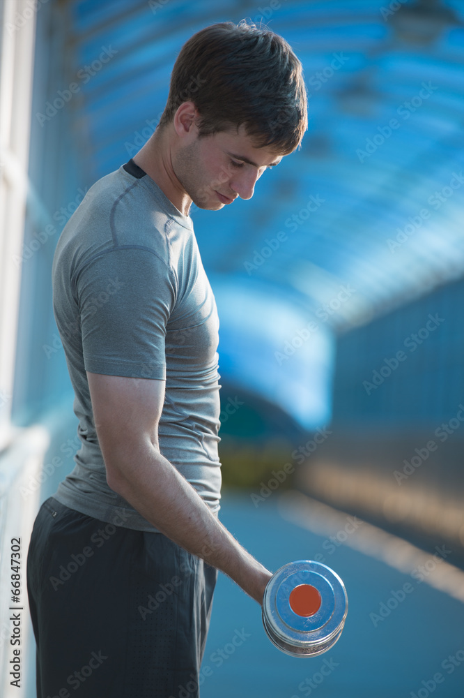 Fototapeta premium Athletic man doing exercises dumbbells