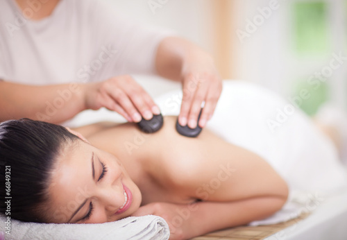 Beautiful woman having a wellness back massage at spa salon with