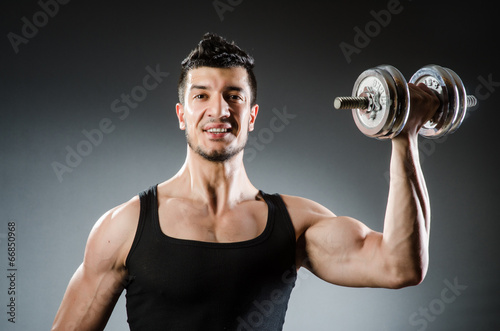 Muscular ripped bodybuilder with dumbbells © Elnur