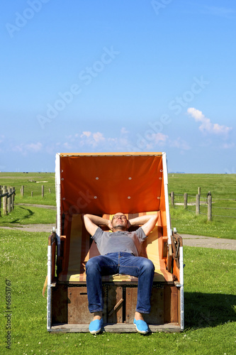 Relaxed man enjoys on a beach chair on the Hallig Langeneß