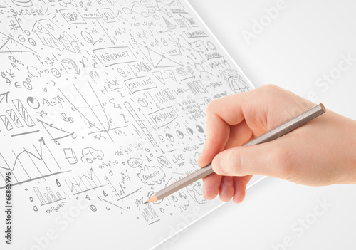 Human hand sketching ideas on a white paper
