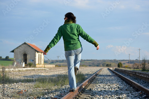 mujer haciendo equilibria en las vias del tren photo