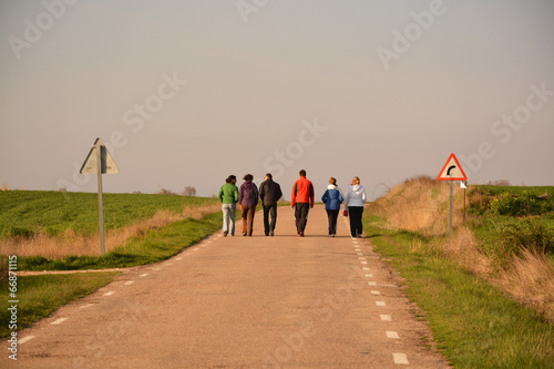 grupo de seis personas caminando por una carretera photo