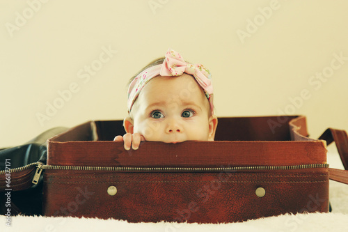 Portrait of aborable baby lying in vintage bag photo