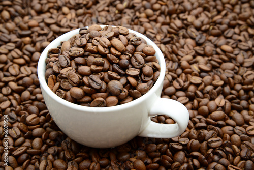 cup with coffee grains on a coffee beans background