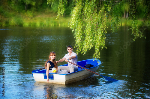 Canvas Print Loving couple in the boat. Summer vacation concept.