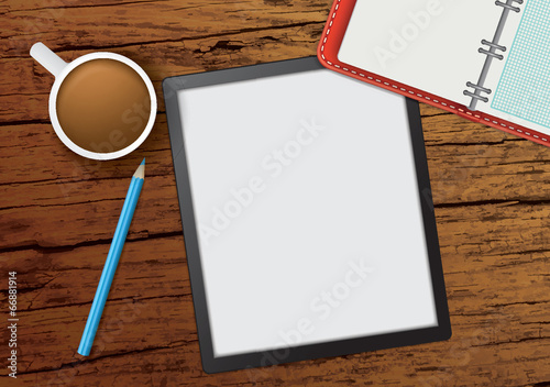overhead view looking down onto a wooden desk with tablet