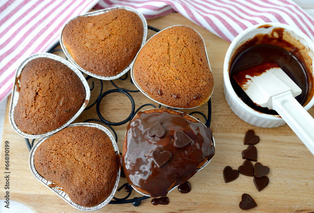 Homemade cakes are being coated with chocolate icing . Homemade cakes are being coated with chocolate icing .