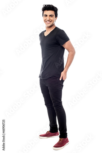 Casual man standing with his hands behind