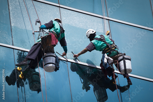 group of workers cleaning windows service on high rise building