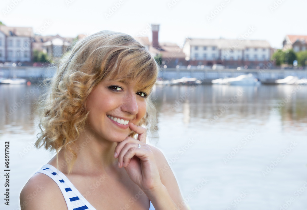 Fototapeta premium Young woman on a river laughing at camera