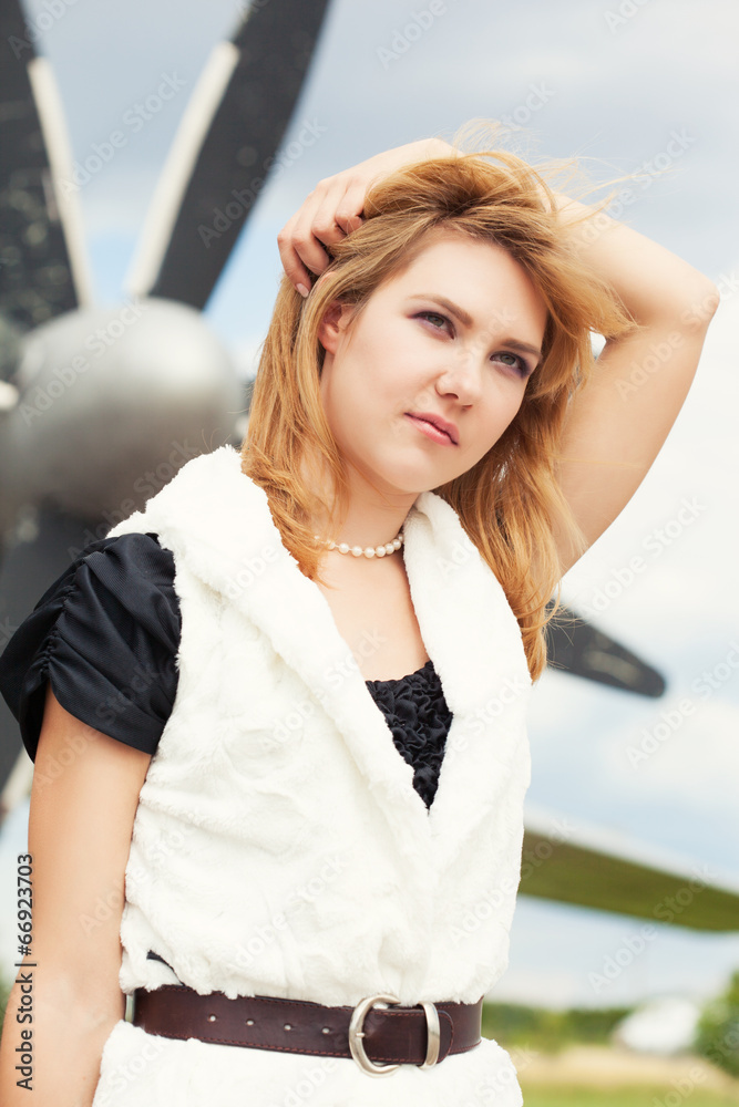 beautiful woman posing against plane