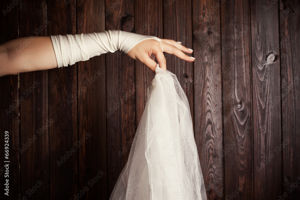 Naklejka premium bride holding a veil against wooden background