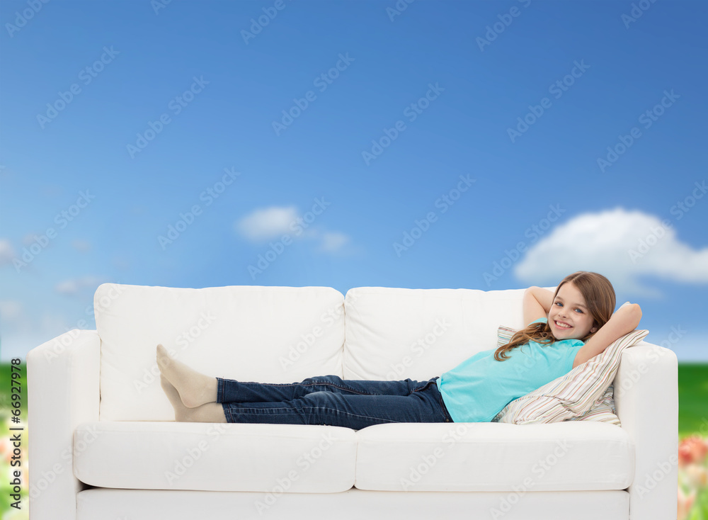 smiling little girl lying on sofa