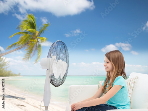 smiling little girl with big fan at home