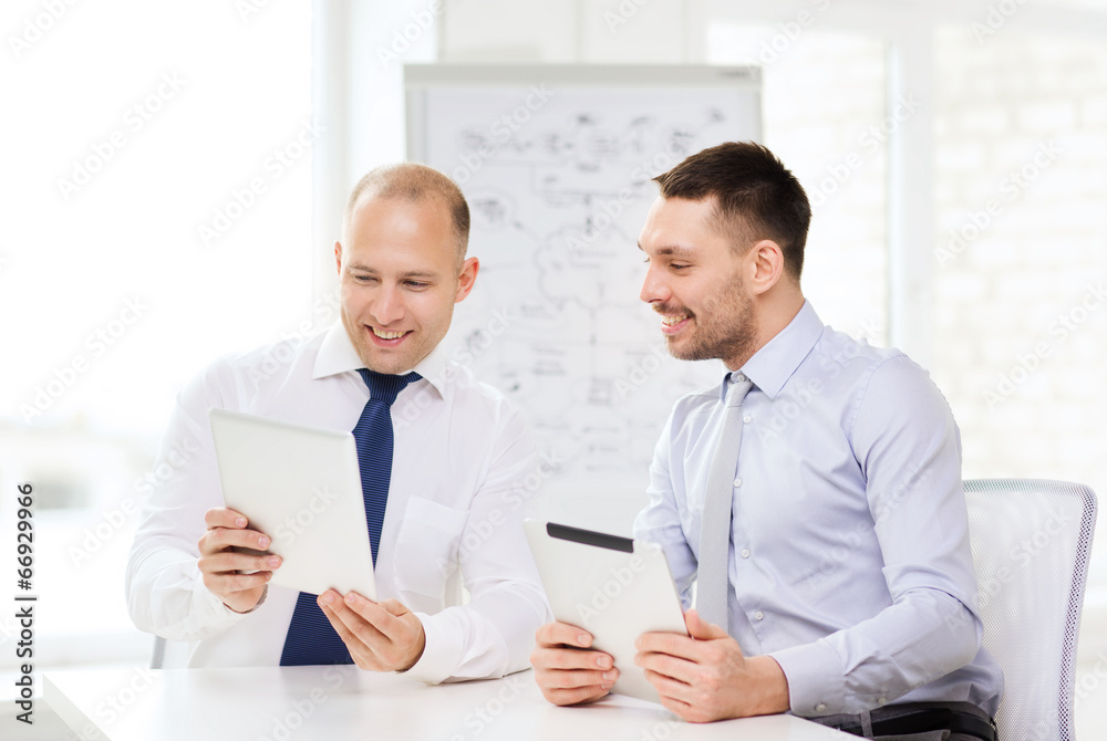 Fototapeta premium two smiling businessmen with tablet pc in office