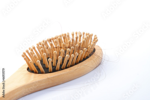 Wooden comb brush with lost hair isolated