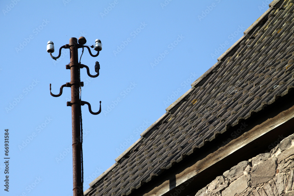 Alter Strommast auf einem Dach