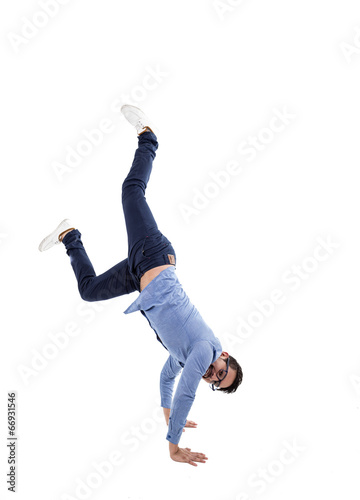 young hispanic man with blue shirt and glasses doing cartwheel