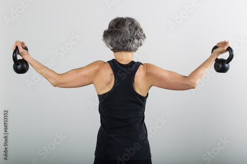 Middle Aged Female Sports Trainer With Kettle Bells