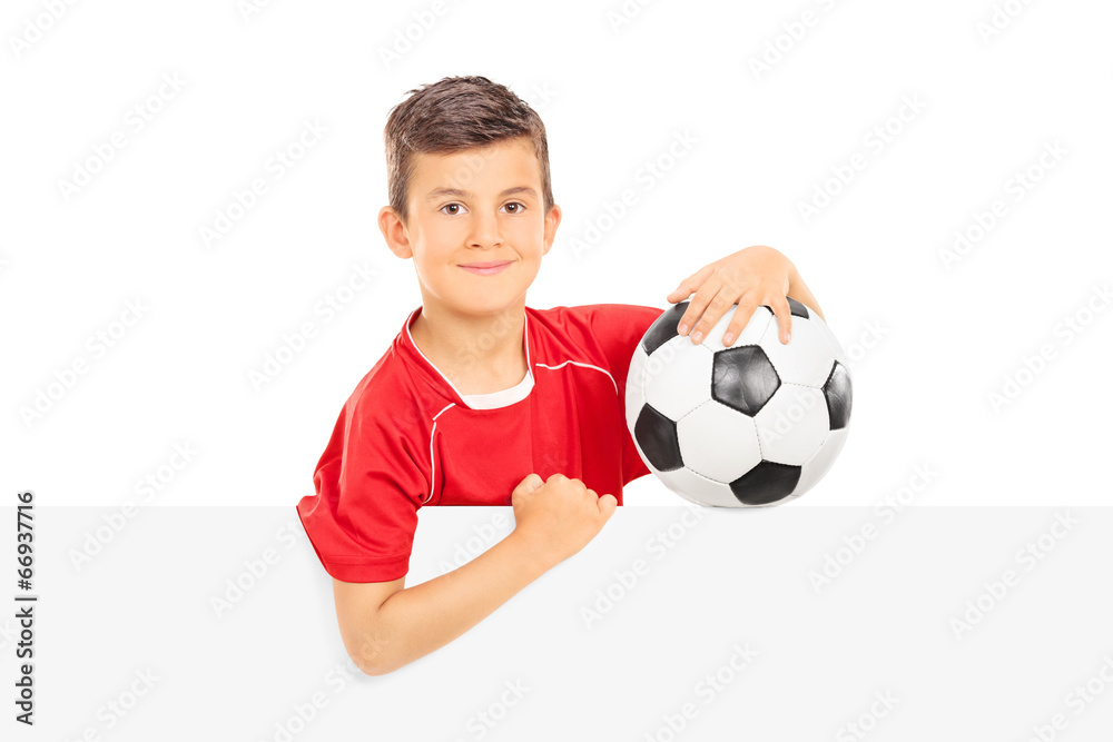 Kid holding a football behind a blank panel