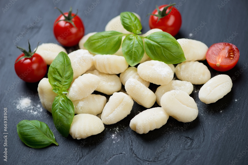 Raw gnocchi with cherry tomatoes and green basil, close-up Raw gnocchi with cherry tomatoes and green basil, close-up