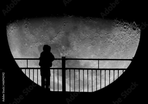Silhouette of a child staring at the Moon. Science education.