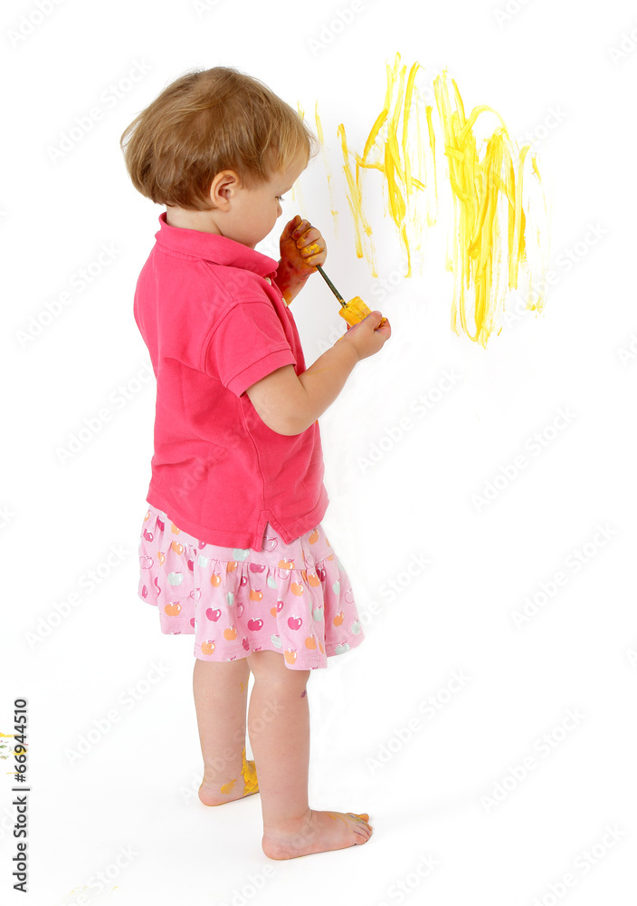 malująca dziwczynka żółtą farbą po ścianie - obrazy, fototapety, plakaty 